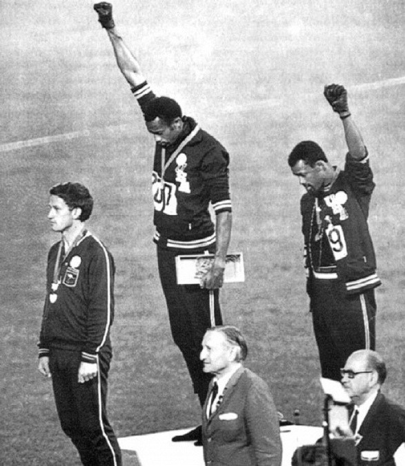 7. Quyền lực Đen: Thời điểm Olympic 1968 diễn ra, phân biệt chủng tộc vẫn còn là vấn đề lớn ở nước Mỹ. Hai VĐV Tommy Smith (giữa) và Juan Carlos (phải) giơ tay trên bục huy chương để thể hiện niềm tự hào màu da của mình, trong khi VĐV Peter Norman (trái) của Australia đeo huy hiệu của chương trình Olympic vì Nhân Quyền. Một trong những thông điệp chính trị mạnh mẽ nhất và gây tranh cãi nhất vào thời điểm đó, sự kiện này khiến Smith và Carlos sau đó bị cấm hoạt động thể thao.